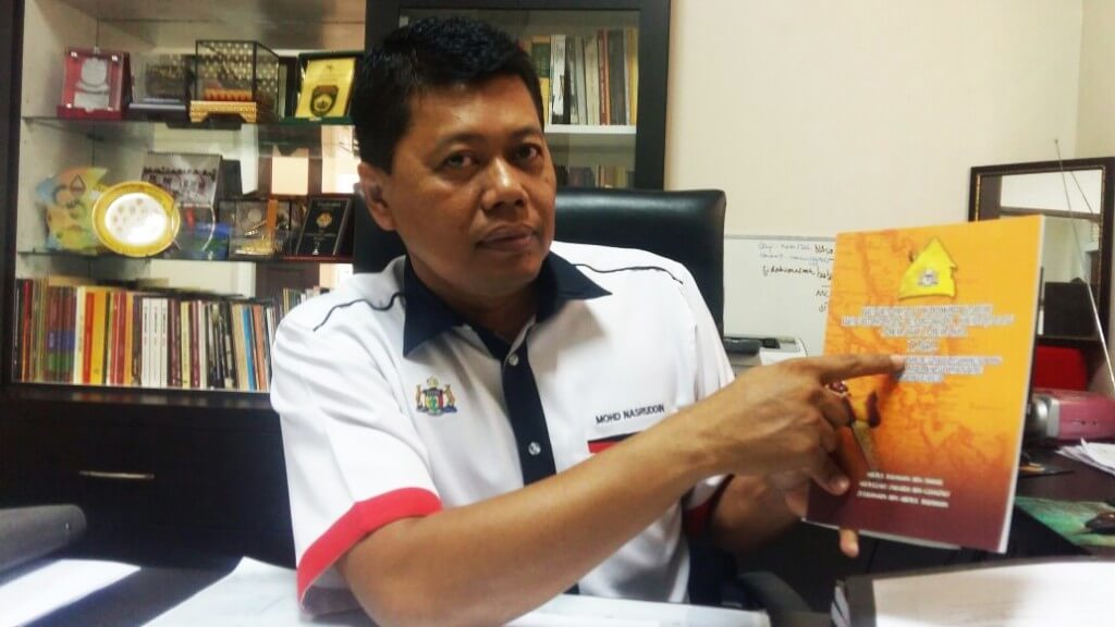 Drs. Mohd Nasruddin menunjukkan buku pentarikhan baru Melaka.