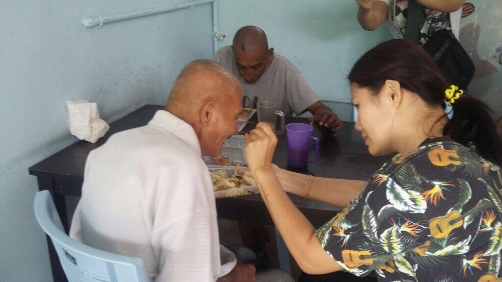 Rachel (kanan) menyuapkan makanan kepada salah seorang penghuni warga emas di Pertubuhan Kebajikan Warga Emas Nazareth.