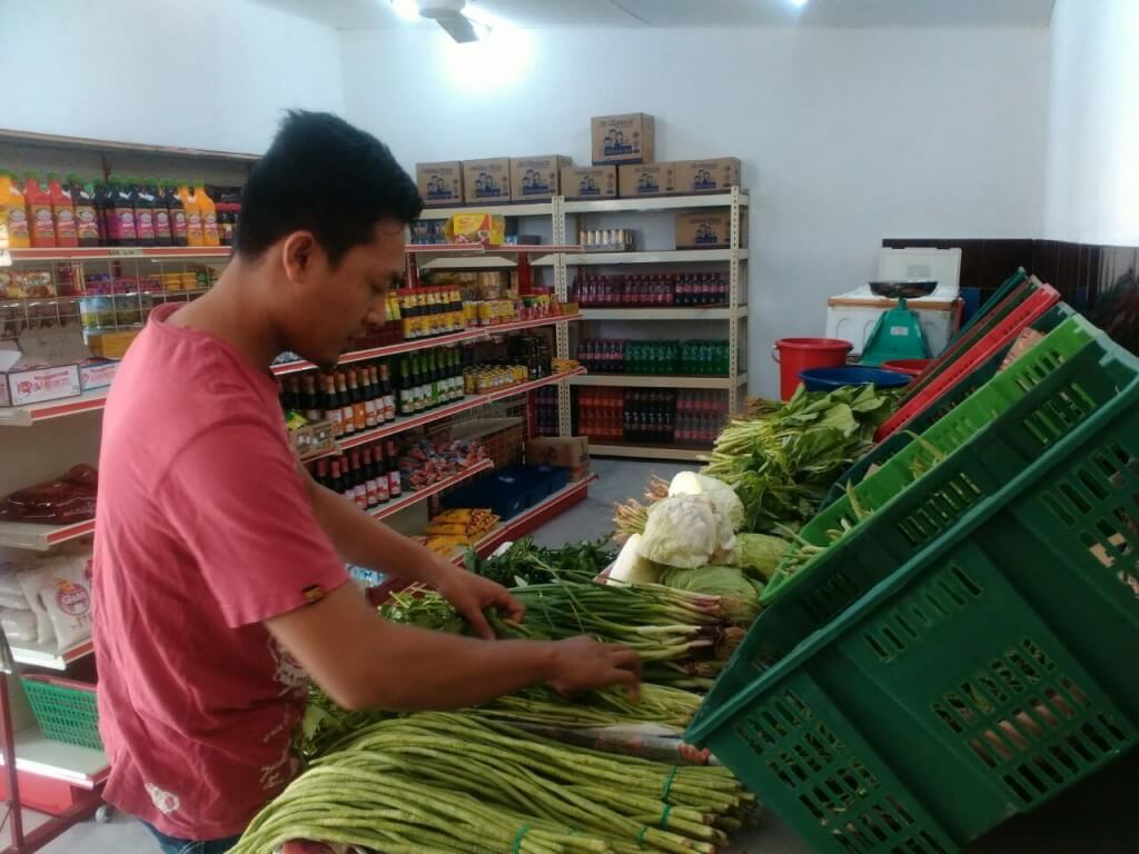 Anuar sedang menyusun sayur-sayuran untuk dijual