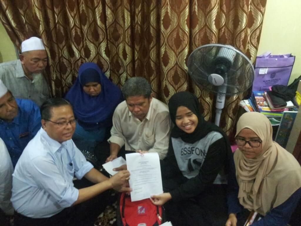 Datuk Seri Ismail Sabri menyerahkan surat tawaran kemasukan ke MRSM kepada Aliyah Maisara
