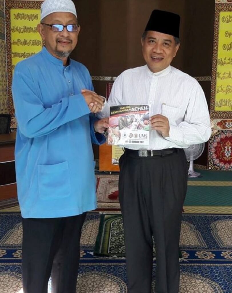 Samin (Kanan) menyerahkan Tabung Kemanusiaan Acheh kepada Pengerusi Jawatankuasa Masjid Daerah Putatan, Mohd Yunus Ismail