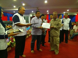 Datuk Haji Zawawi Haji Othman (dua dari kiri) menyampaikan sijil kepada penerima RMR1M di Pasir Puteh