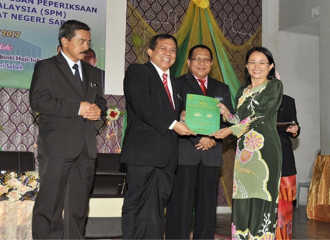 Pengetua SM St Micheal Penampang, Jennifer Asing (kanan) menerima Anugerah Pencapaian Cemerlang SPM bagi sekolah-sekolah seluruh Sabah dari Timbalan Pengarah Pendidikan Sabah, Datuk Dr.Mohamad Kassim Ibrahim.