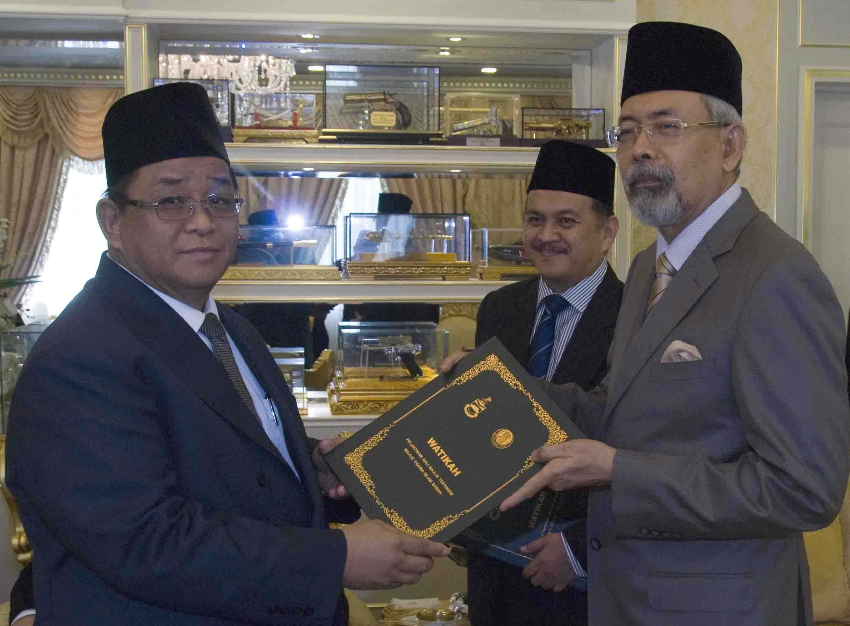 Allahyarham Suhaili (kiri) ketika menerima Watikah sebagai Ahli Majlis Tertinggi MUIS daripada Yang Dipertua Negeri, Tun Haji Juhar Datuk Mahiruddin di Istana Negeri pada 27 Ogos 2014.