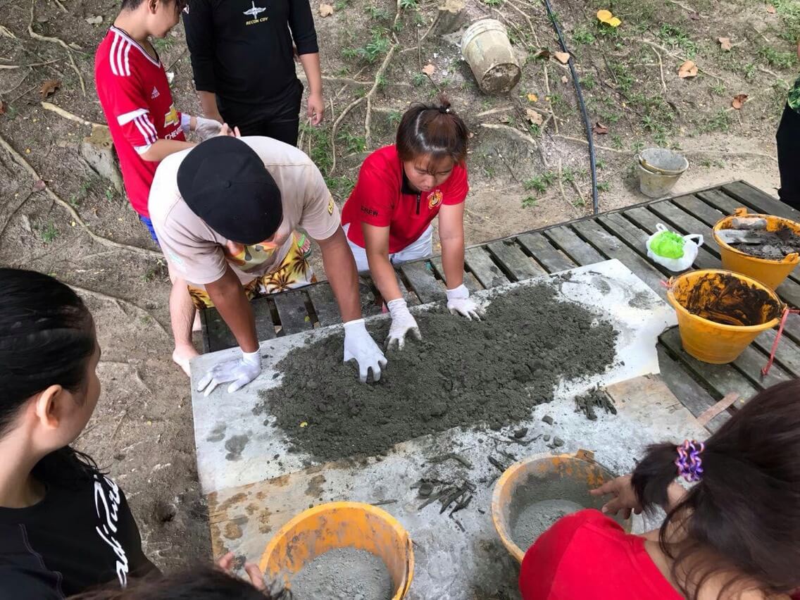Pekerja Mari Mari Pulau Sepanggar menunjukkan cara-cara membuat plaster batu bata kepada ahli-ahli Persatuan Pelancongan Backpackers, AIC. 