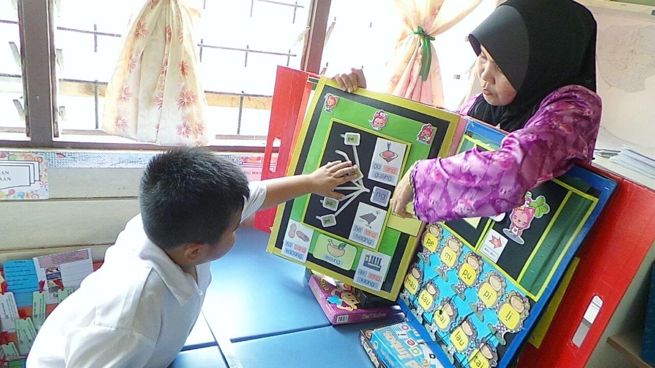 Siti Aminah menunjukkan kaedah pembelajaran menggunakan buku besar.