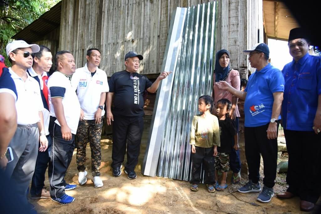 Juslie (dua dari kanan) dan Suwadi (lima dari kiri) ketika hadir ke rumah Arbayah menyampaikan sumbangan peralatan baiki rumahnya semasa pelaksanaan program CTU pada Sabtu.