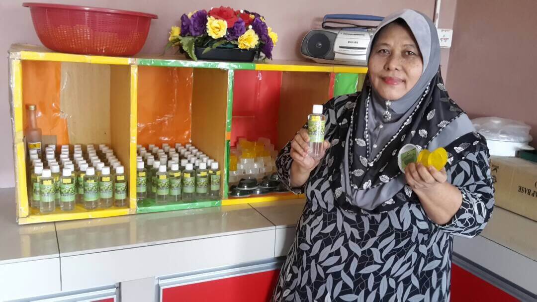 Siti Zabidah bersama produk Minyak Kelapa Dara keluaran mereka.