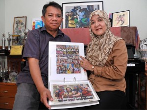 Sulin (kanan) dan Mat Salleh (kiri) tidak jemu melihat koleksi keratan akhbar mengenai kejayaan Fatin.