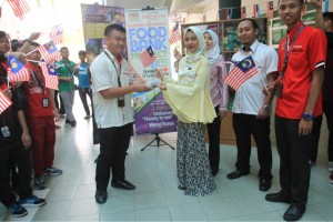 Zainab sedang menyampaikan makanan kepada para pelajar yang terlibat 