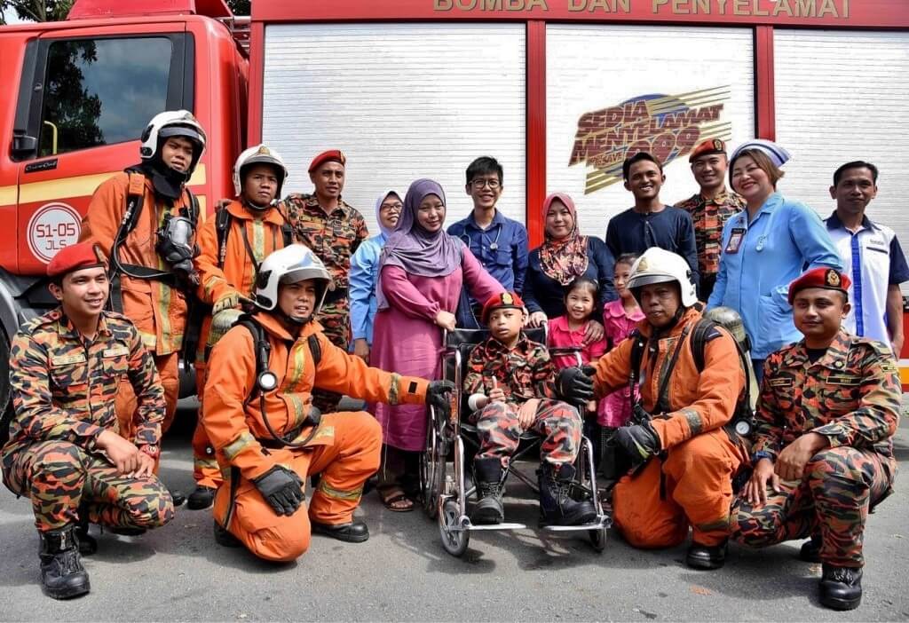 Faisul (berkerusi roda) bersama anggota bomba dan kakitangan hospital.