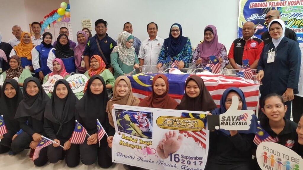 Ahli-ahli kelab 1Malaysia daripada Sekolah Menengah Kebangsaan Perlis dan Sekolah Menengah Kebangsaan Putra bergamar bersama bayi-bayi Hari Malaysia di Hospital Tuanku Fauziah.
