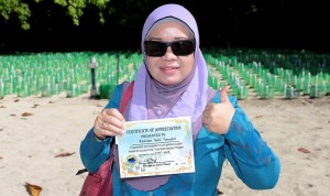 Rozidah bersama sijil pengangkatan penyu yang diberikan oleh Taman-Taman Sabah