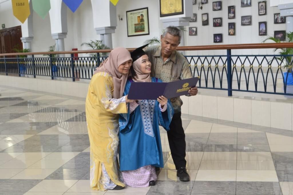 Nurina menunjukkan ijazah miliknya kepada ibu dan bapanya di Majlis Konvokesyen UIAM di Kampus Gombak, siang tadi.
