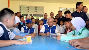 Mohd Haikal (dua dari kanan) ketika membaca karangannya bertajuk 'Sekolah Baharu Saya' sambil diperhatikan Najib (tiga dari kanan) dan Dexter (belakang, tengah). 