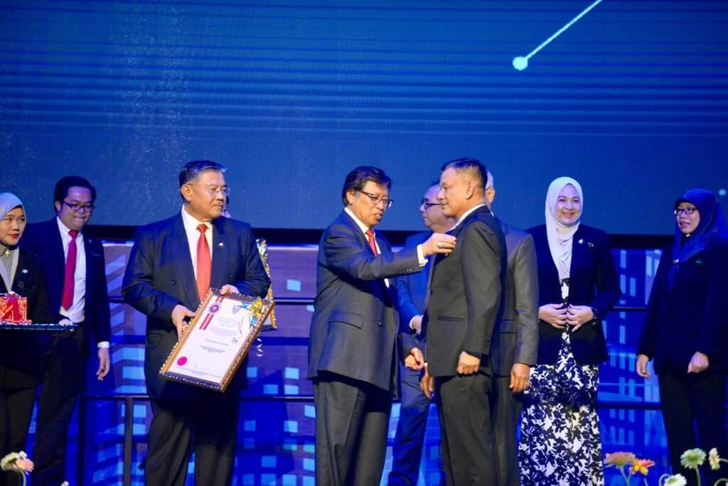 Abang Johari (tengah) menyampaikan Anugerah Perkhidmatan Contoh kepada Hamdan.