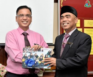 Mohd Fadzil (kiri) menerima cenderhati daripada Diuh (Kanan).