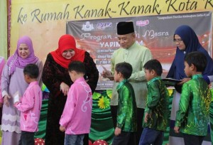 Rosnah (tengah) mengagihkan sumbangan bantuan wang tunai pertama kepada penghuni rumah kanak-kanak.