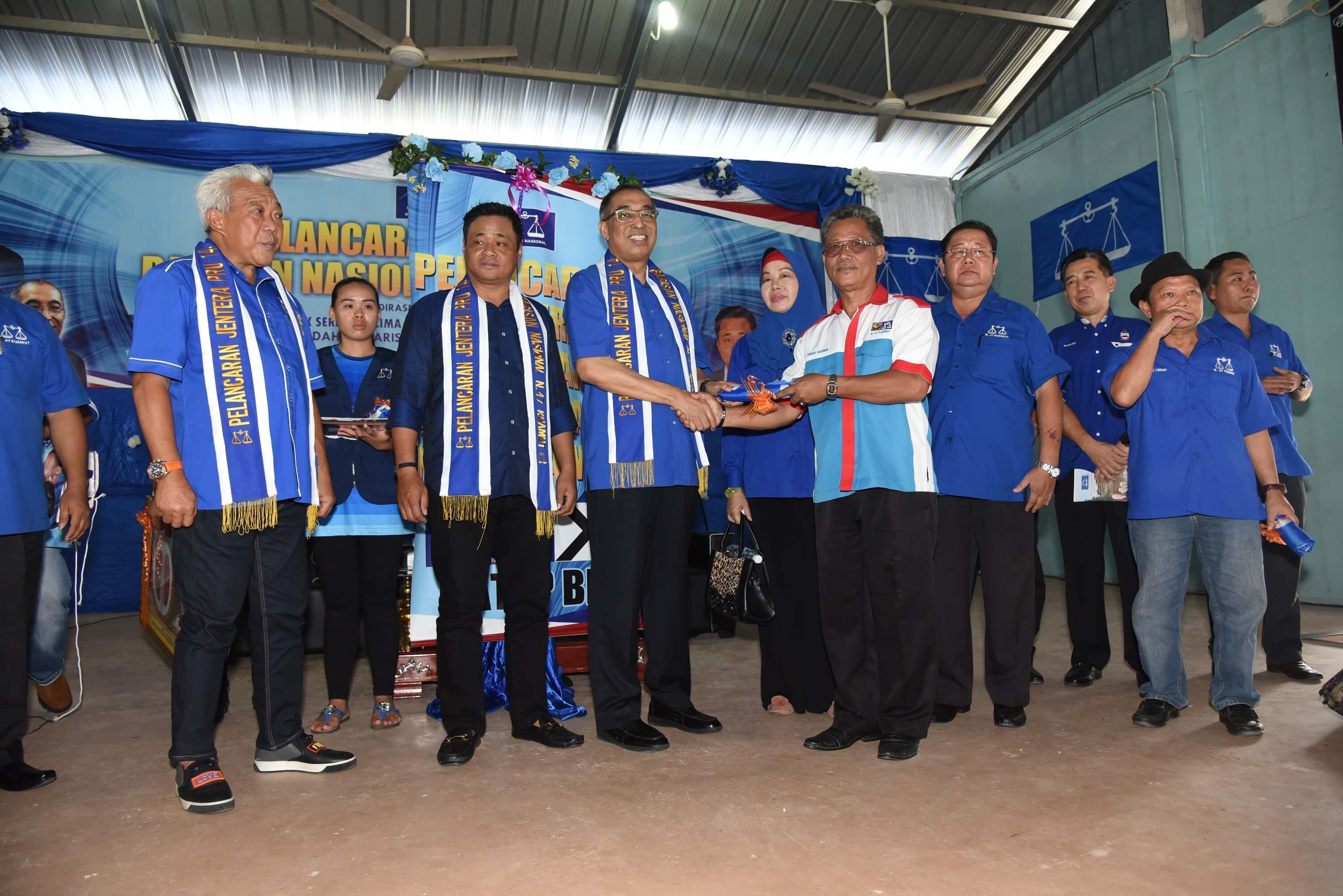 Salleh menyerahkan bendera kepada Pengarah Jentera Pilihan raya Parti Bersatu Sabah kawasan Kuamut, Awang Gariman (tiga kanan) sambil disaksikan Bung Moktar (kiri) dan Masiung (dua kiri).