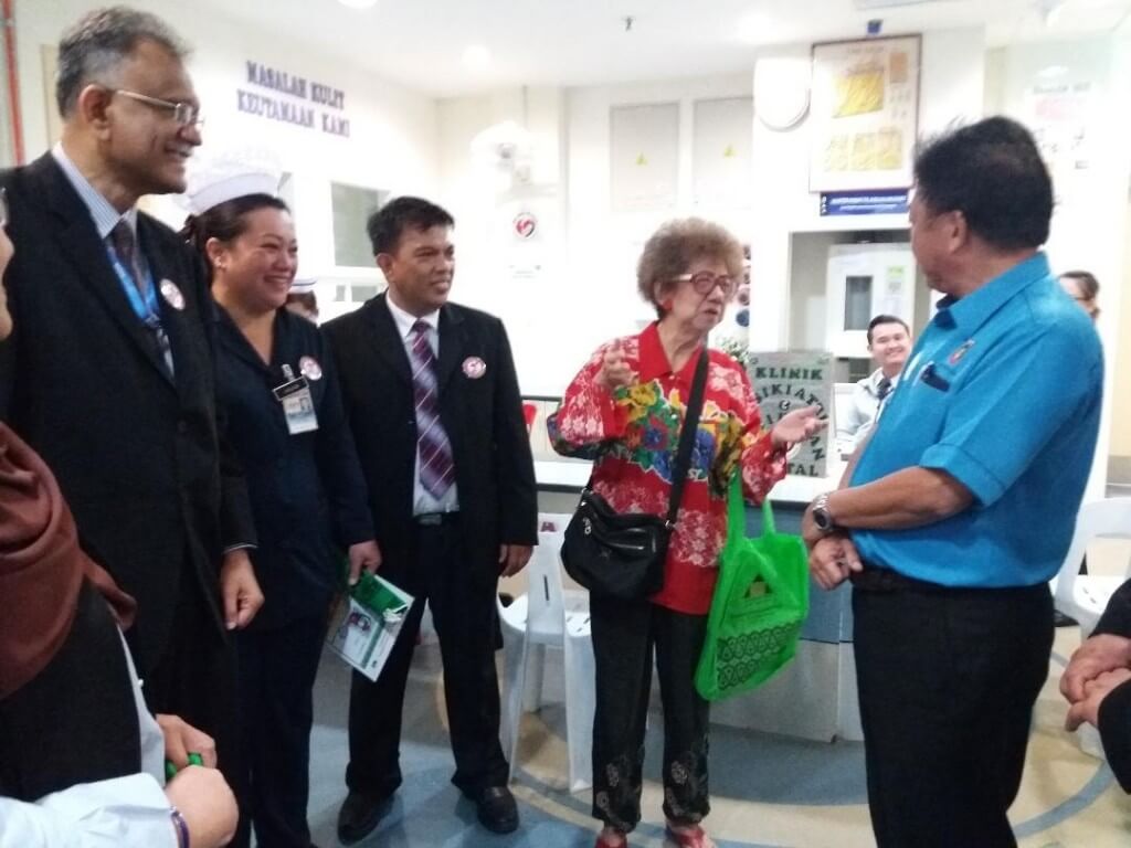 Datuk Yeo Boon Hai  berkesempatan beramah mesra dengan  pelanggan HQE  di klinik berdekatan sambil diperhatikan Dr. Heric (kiri).