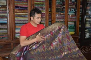 Syukri menunjukkan kain songket India di tangannya yang kualitinya sangat nipis dan terlalu sempurna kerana diperbuat menggunakan mesin.
