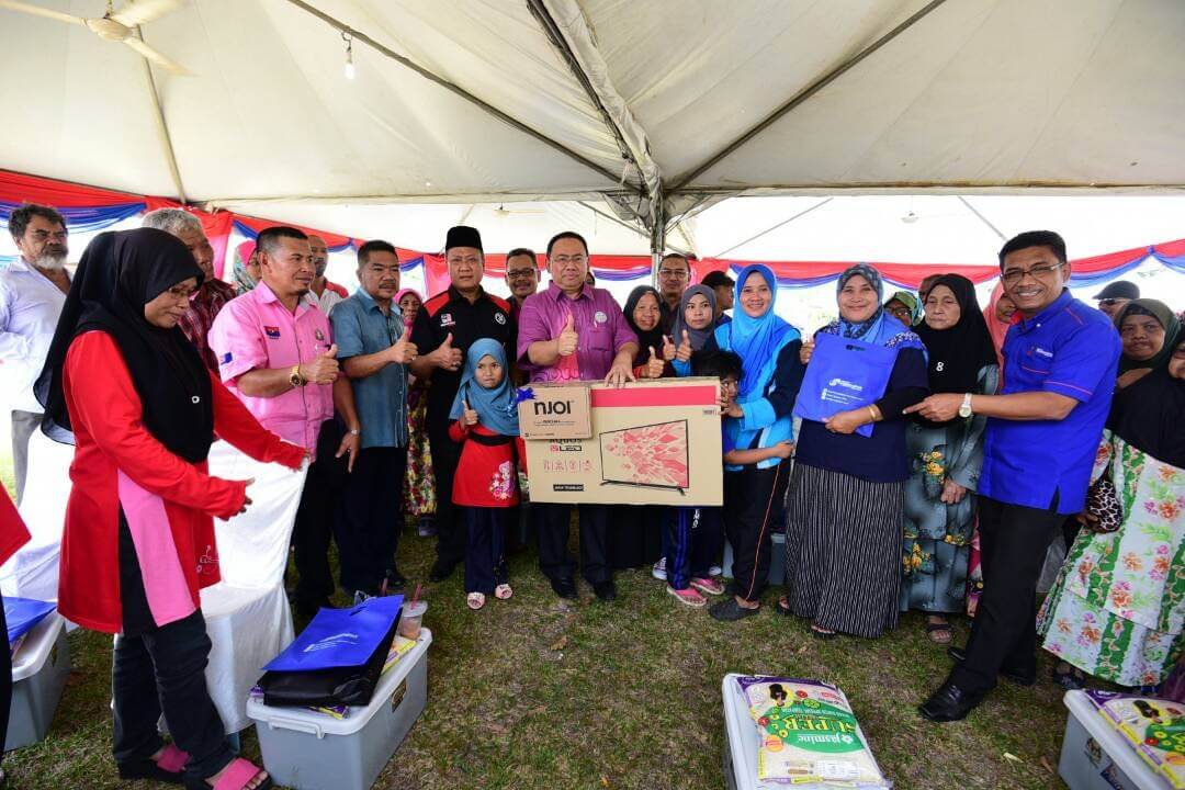 Mohd Shukri (tengah) bersama- sama penduduk Kampung Pak Kalib semasa acara penyerahan bantuan kepada warga kampung