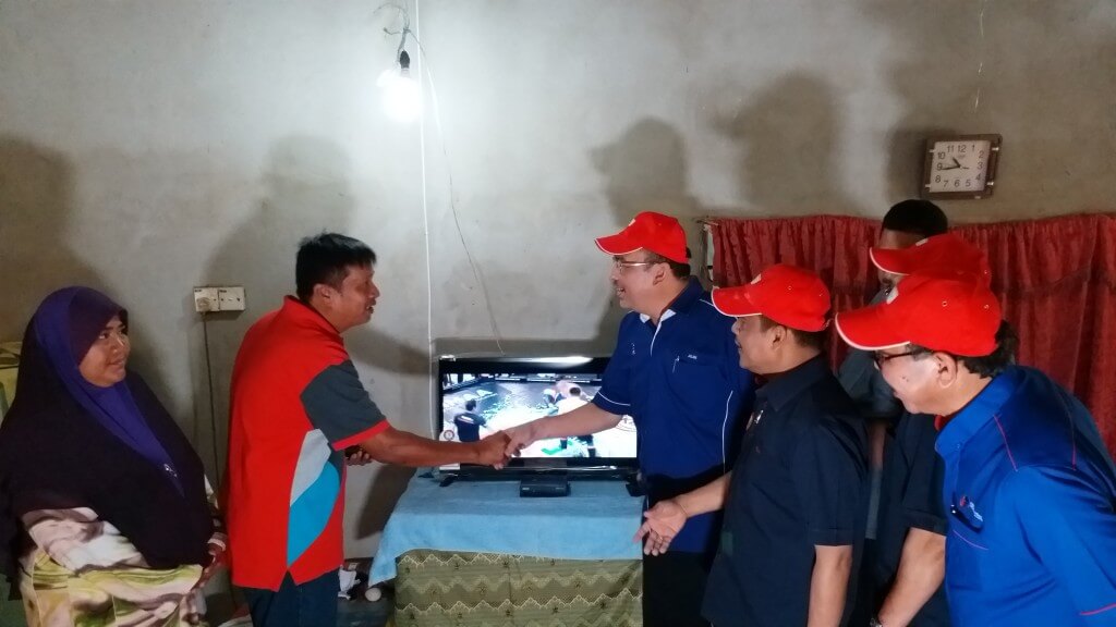 Datuk Sri Jailani, Ketua Pengarah Jabatan Penerangan Malaysia dan ADUN Belantik menyampaikan sumbangan TV beserta set astro Njoi dan barangan keperluan kepada salah seorang penerima