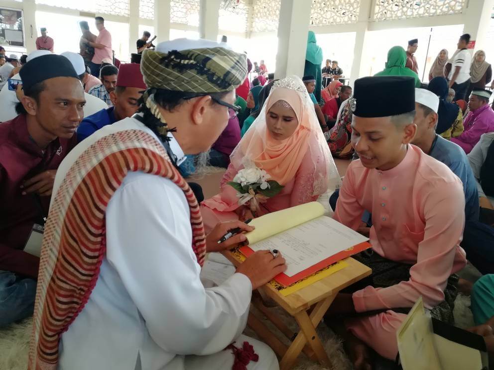 Upacara akad nikah pasangan Mohd Afiq Jaafar oleh jurunikah Solahuddin Ramli disaksikan oleh pegawai daerah serta hadirin.