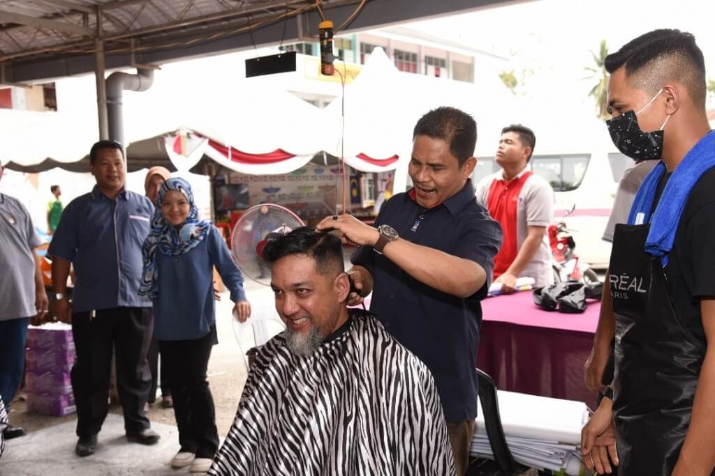 Datuk Haji Mohd Tajudin Abdullah menunjukkan bakatnya menggunting rambut wartawan Malaysiaaktif