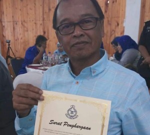 Abdul Razak Hamid bersama Surat Penghargaan yang diterimanya daripada Ketua Polis Bandar Baharu