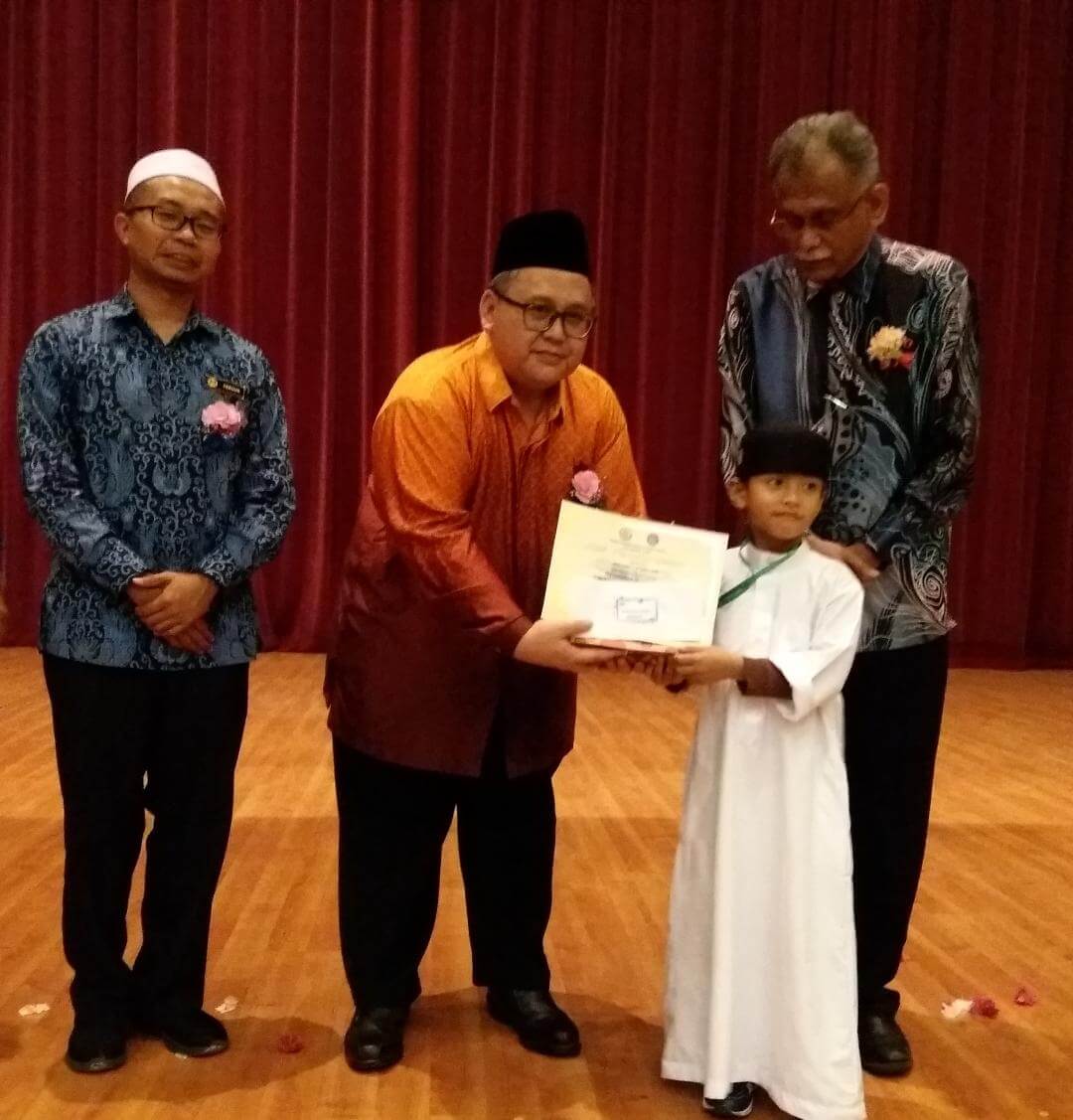 Junaidi turut menyampaikan hadiah kepada salah seorang peserta bagi kategori Hafazan kanak-kanak disaksikan oleh Dr. Heric(kanan) dan Dr. Mohd Ferous (kiri)