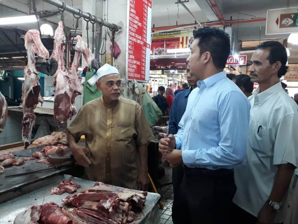 Setiausaha Persatuan Pengguna (CAKE), Mohd Yusrizal berbaju kemeja biru sedang membuat tinjauan terhadap peniaga daging