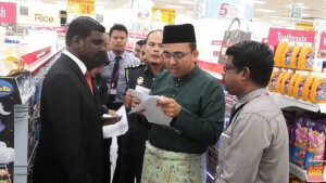 Mohd Rafiq Naizamohideen dan G. Saminathan memantau harga di pasaraya AEON Bandaraya Melaka.