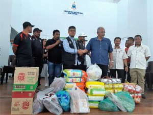 Mohd Zulfikar berjabat tangan dengan Chaco yang menerima sumbangan mewakili mangsa-mangsa kebakaran.