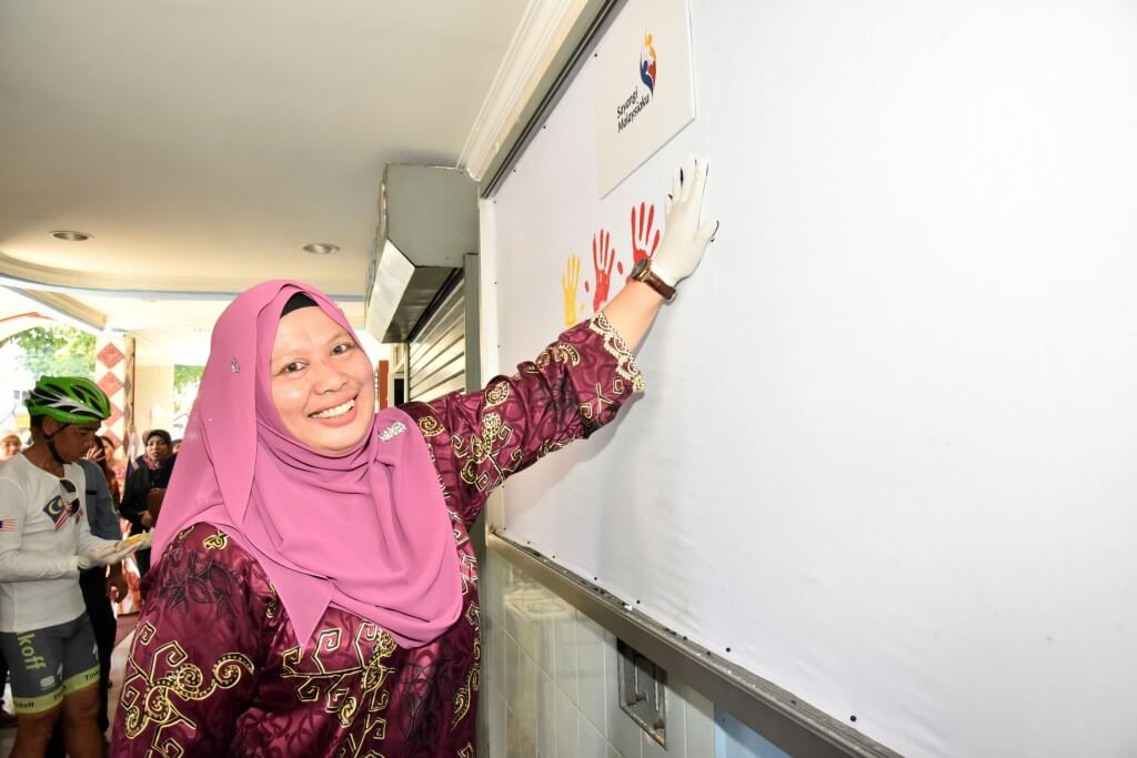 Norzawiyah melekap tapak tangan yang diwarnakan dengan cat sebagai gimik pelancaran Program Merdeka @Komuniti Peringkat Bandaraya Kota Kinabalu 2018.