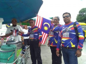 Peserta konvoi KMJG mengedarkan jalur gemilang kepada peniaga pasar tani Kuala Besut