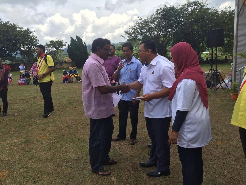 Amirudin (tiga dari kiri) menyampaikan Kad Peduli Sihat kepada salah seorang penerima semasa program Sambutan Hari Malaysia di SMK Sungai Kertas, Batu Caves.