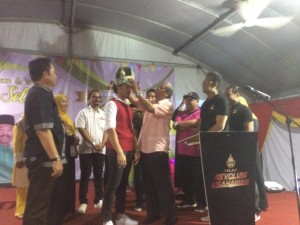 Dr Mohd Hatta memakaikan tengkolok kepada penyanyi Izzmad Harun yang dilantik sebagai Ikon Kelab Revolusi Usahawan.