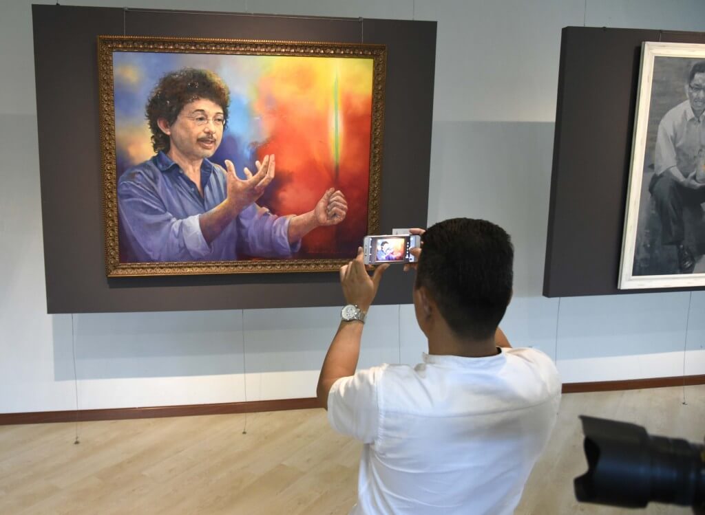 Salah seorang pengunjung yang kelihatan berminat dengan potret yang dipamerkan.