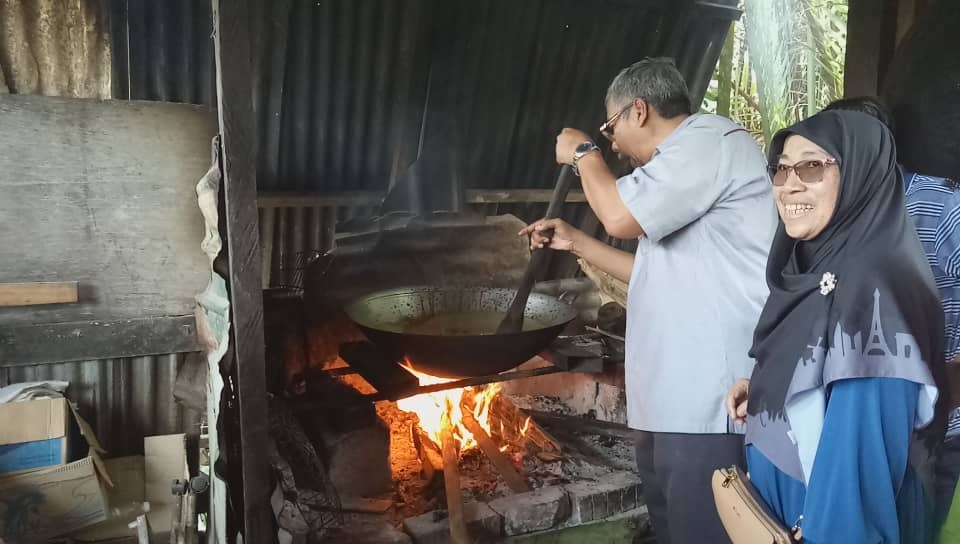Dr Mohd Hatta Bin Md Ramli mencuba sendiri mengaul masakan gula apong semasa lawatannya ke Matu baru-baru ini