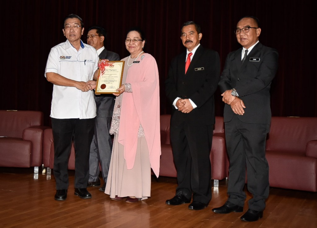 Mistirine (tengah) menyampaikan sijil kepada Guru Besar SRJKC St James Kota Kinabalu (kiri) sambil diperhatikan Abidin (dua dari kanan) dan Mohd. Zaini (kanan)