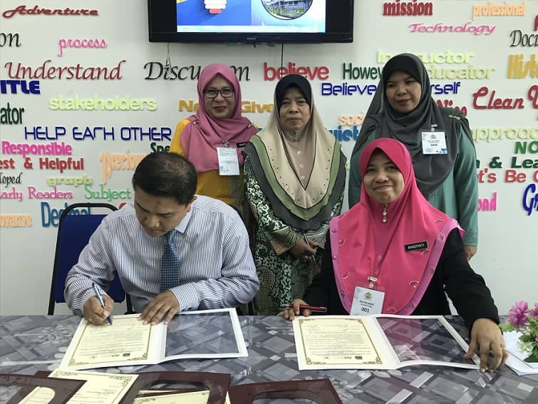 Khaziyati (duduk kanan) dan Pemangku Ketua Bahagian Pentadbiran Jabatan Sekolah Sekolah Kementerian Pendidikan Brunei , Pg. Ahmad Masudwardi Aidil Firtri Pg. Md. Daud menurunkan tandatangan sebagai saksi pada Majlis menandatangani dokumen Perjanjian Permuafakatan Strategik dalam bidang kajian dan inovasi.