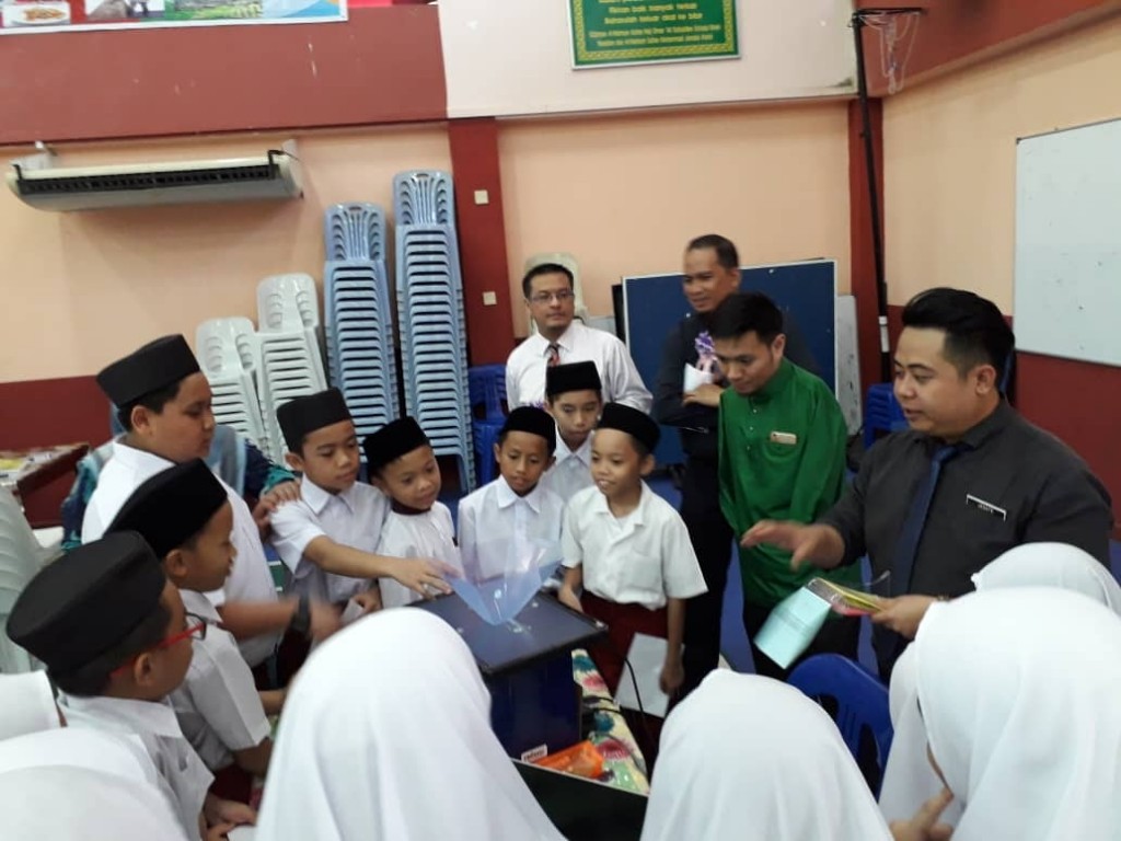 Salah seorang guru JPWPL berkongsi hasil inovasi dengan murid-murid sekolah di Brunei Darussalam