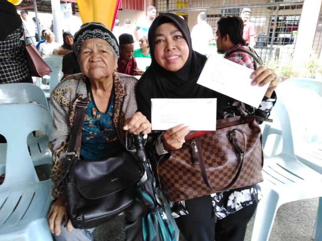 (Dari kiri) Kamariah dan Hamidah gembira menerima Notis 5A Kampung Sungai Serai, hari ini.