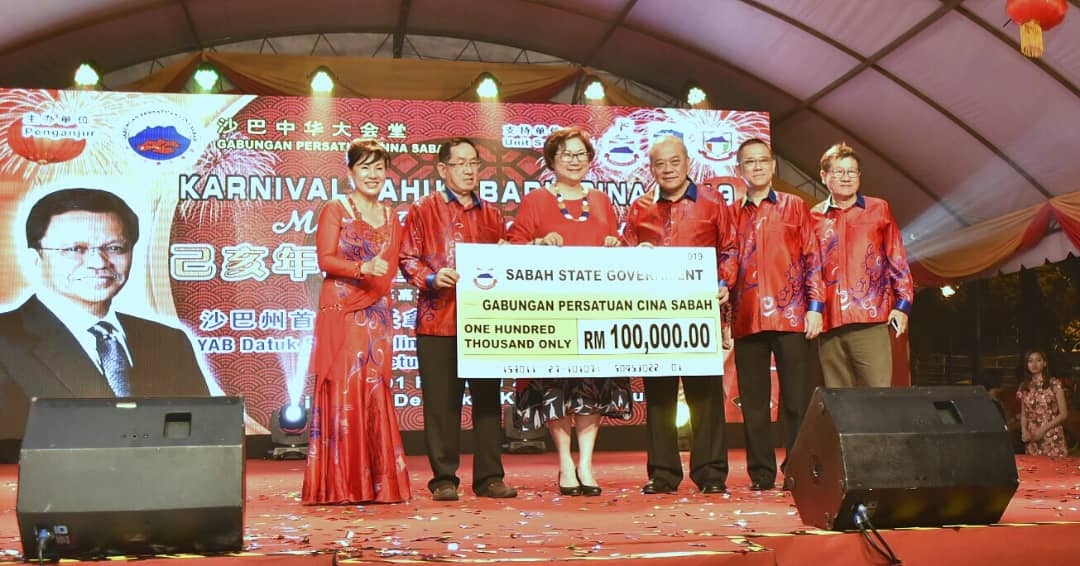 Christina (tengah) menyampaikan Cek Sumbangan Kerajaan Negeri kepada T.C Goh (tiga dari kanan) yang mewakili Gabungan Persatuan Cina Sabah