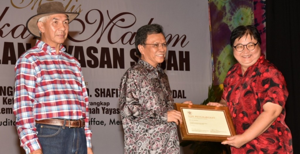 Shafie (tengah) diiringi Jamalul (kanan) menyampaikan anugerah kepada salah seorang penerima Anugerah Perkhidmatan Jubli Perak.