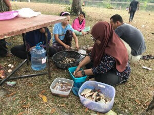 Menyiang ikan untuk dimasak dan dimakan bersama-sama.