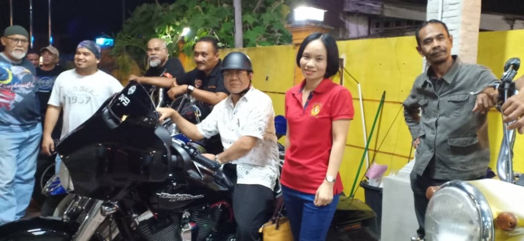 Pengarah Jabatan Penerangan Kelantan, Lim Ann Teck bertopi duduk atas motor