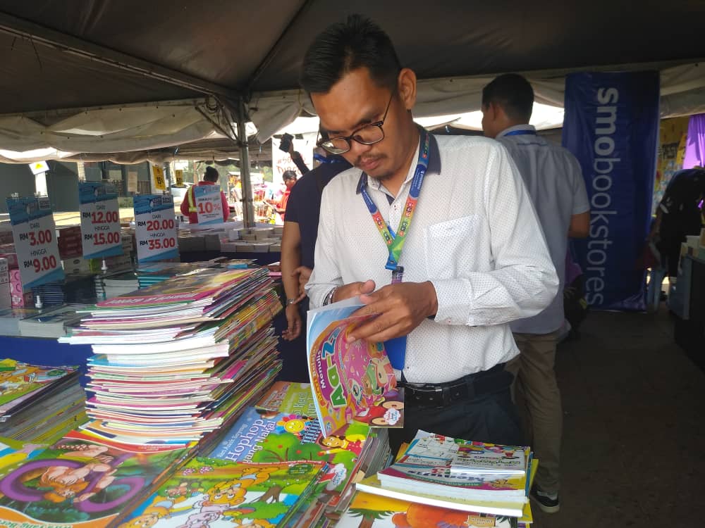 Salah seorang pengunjung sedang asyik membelek bahan bacaan kanak-kanak sempena Pesta Buku Pahang.