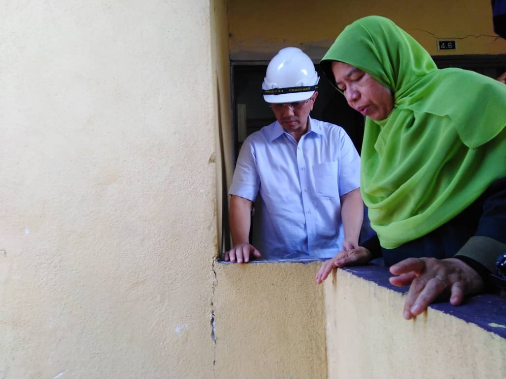 Zuraida (kanan) bersama Azmin ketika meninjau Blok F Pangsapuri Keramat Permai yang terjejas akibat struktur bangunan retak sejak Jumaat lalu.